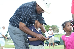 Champions Tour player Jim Dent shows the golf grip to Jerimiah, while his sister Michaela waits her turn during the golf clinic held at the West Palm Beach Golf Course, during the African American Golfers Hall of fame golf clinic on May 29, 2010.