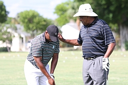 Stanley A. Wilson, Jr. gets a golf tip from Champions Tour Jim Dent at the African American Golfers Hall of Fame golf clinic, May 29, 2010.